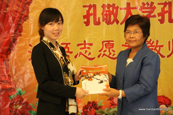 图片四：孔子学院泰方院长向新志愿者赠送孔院画册.JPG